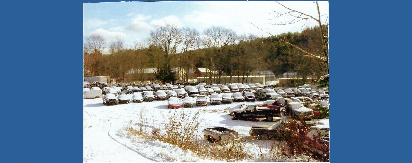 Rows of cars parked in a snowy lot.